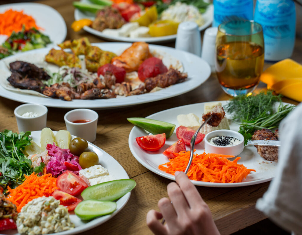 Traditional Balinese dish with rice, grilled fish, vegetables, and sambal on a wooden table in Nusa Penida, Indonesia