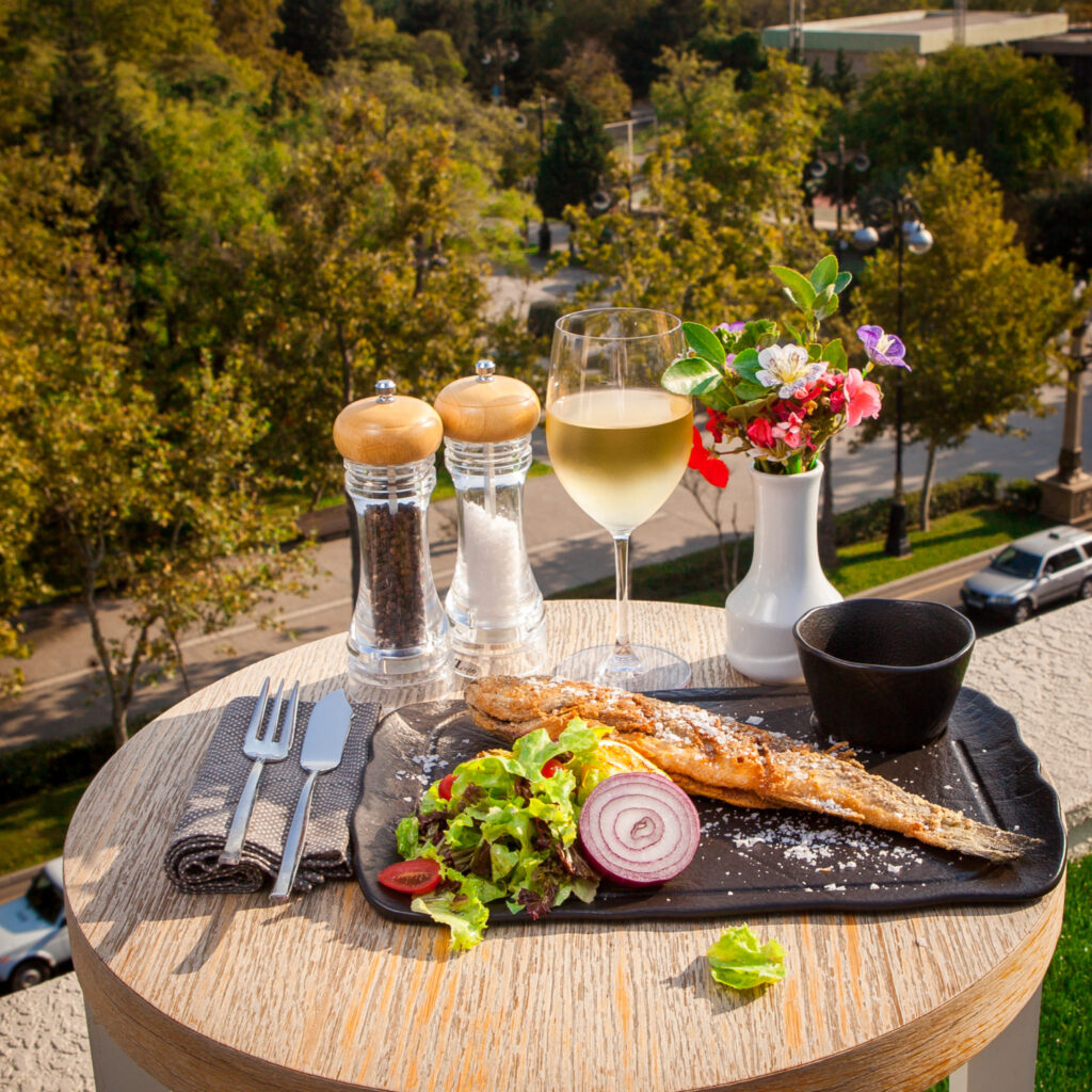 A beautifully arranged plate of traditional Argentine asado with juicy steaks, grilled vegetables, and chimichurri sauce, set on a rustic wooden table