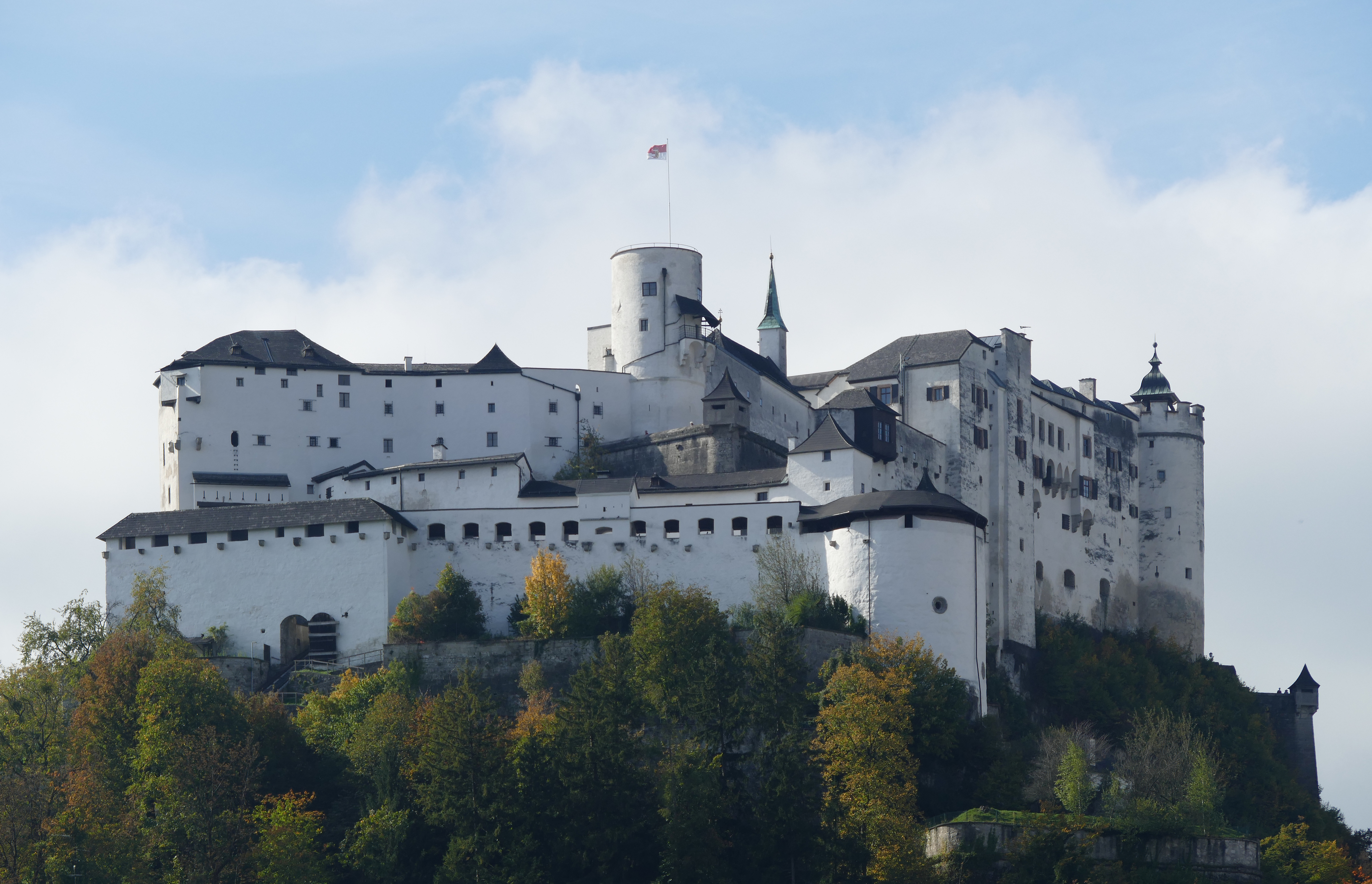 A panoramic view of Hohensalzburg Fortress perched atop a hill, overlooking the city of Salzburg, Austria.