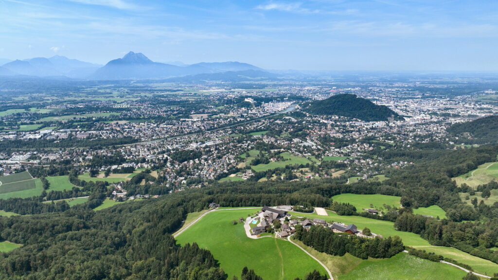 A picturesque view of Salzburg City, Austria, featuring the historic Old Town with Baroque architecture, the Salzach River, and Hohensalzburg Fortress perched on a hill.