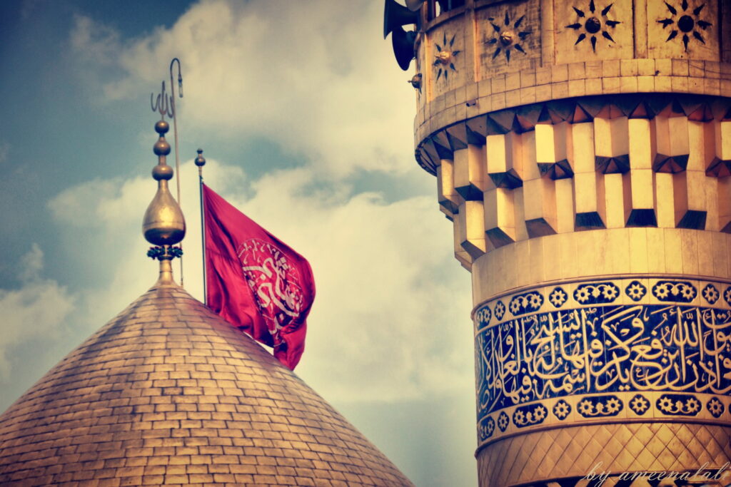 Shrine of Hazrat Abbas in Karbala, Iraq, featuring a golden dome and minarets surrounded by pilgrims and colorful decorations