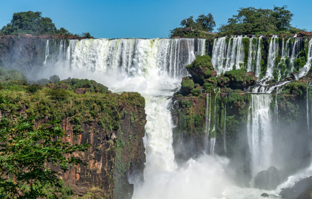 A breathtaking view of a cascading waterfall surrounded by lush greenery and rocks
