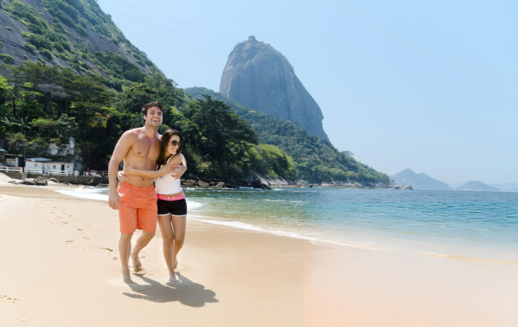 A picturesque view of Ipanema Beach with golden sand, turquoise water, and surrounding mountains