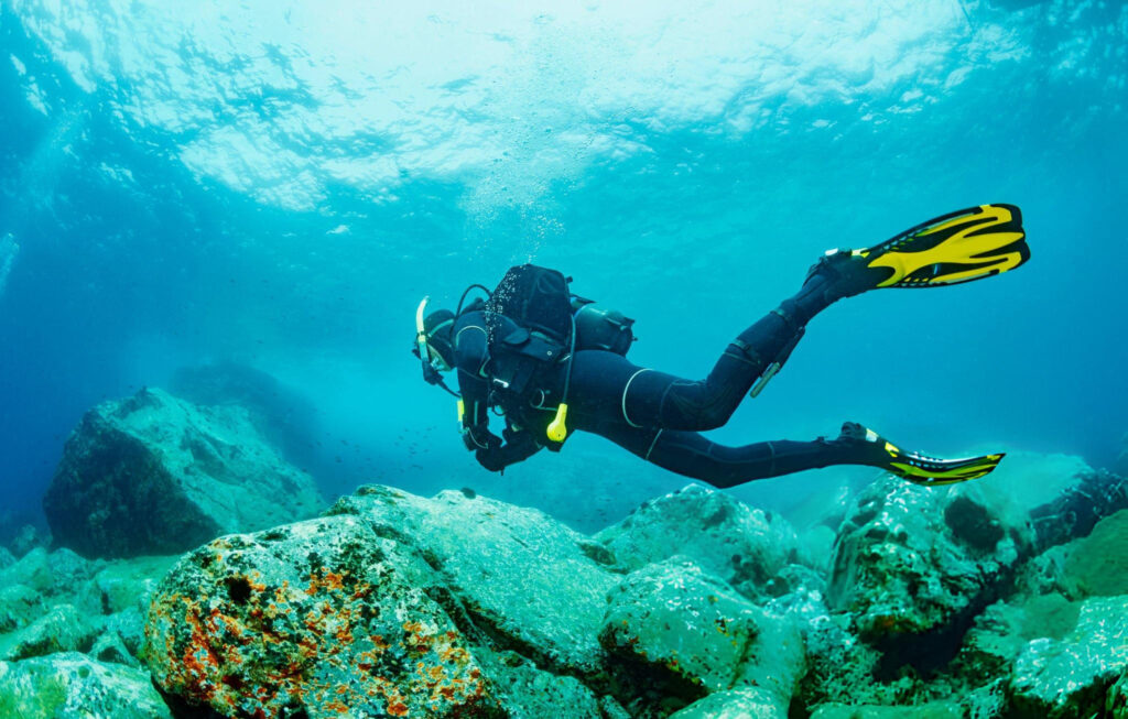 A diver exploring the clear underwater world of Lake Baikal, surrounded by stunning ice formations and unique aquatic life