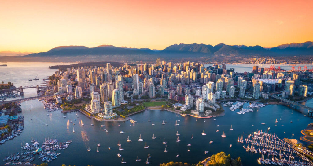 Overview of Vancouver, Canada, featuring the city skyline, waterfront, coastal mountains, and lush greenery of Stanley Park
