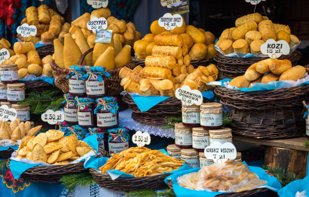An assortment of traditional Polish dishes including pierogi, kwaśnica, and oscypek