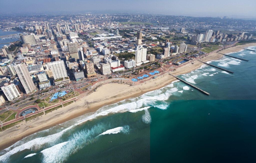 A scenic aerial view of Durban city showcasing its coastline, high-rise buildings, and the Indian Ocean