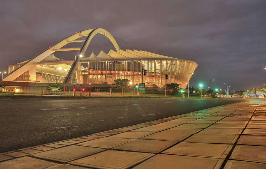 A wide view of the Moses Mabhida Stadium in Durban with its iconic arch and surrounding greenery