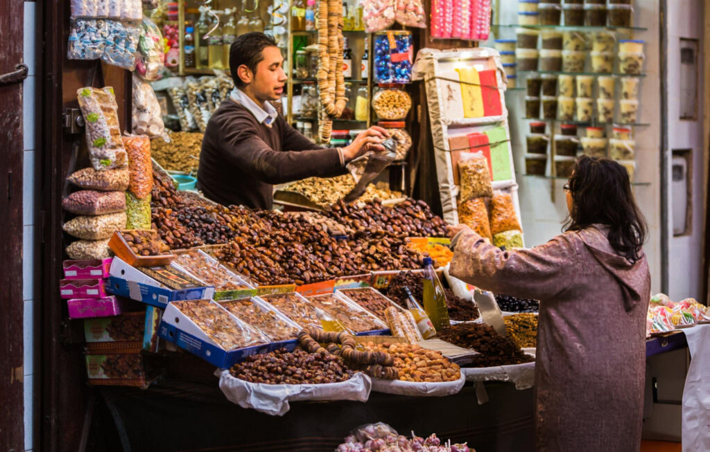 A street vendor in Fes selling traditional Moroccan food from a stall, with various dishes displayed for customers