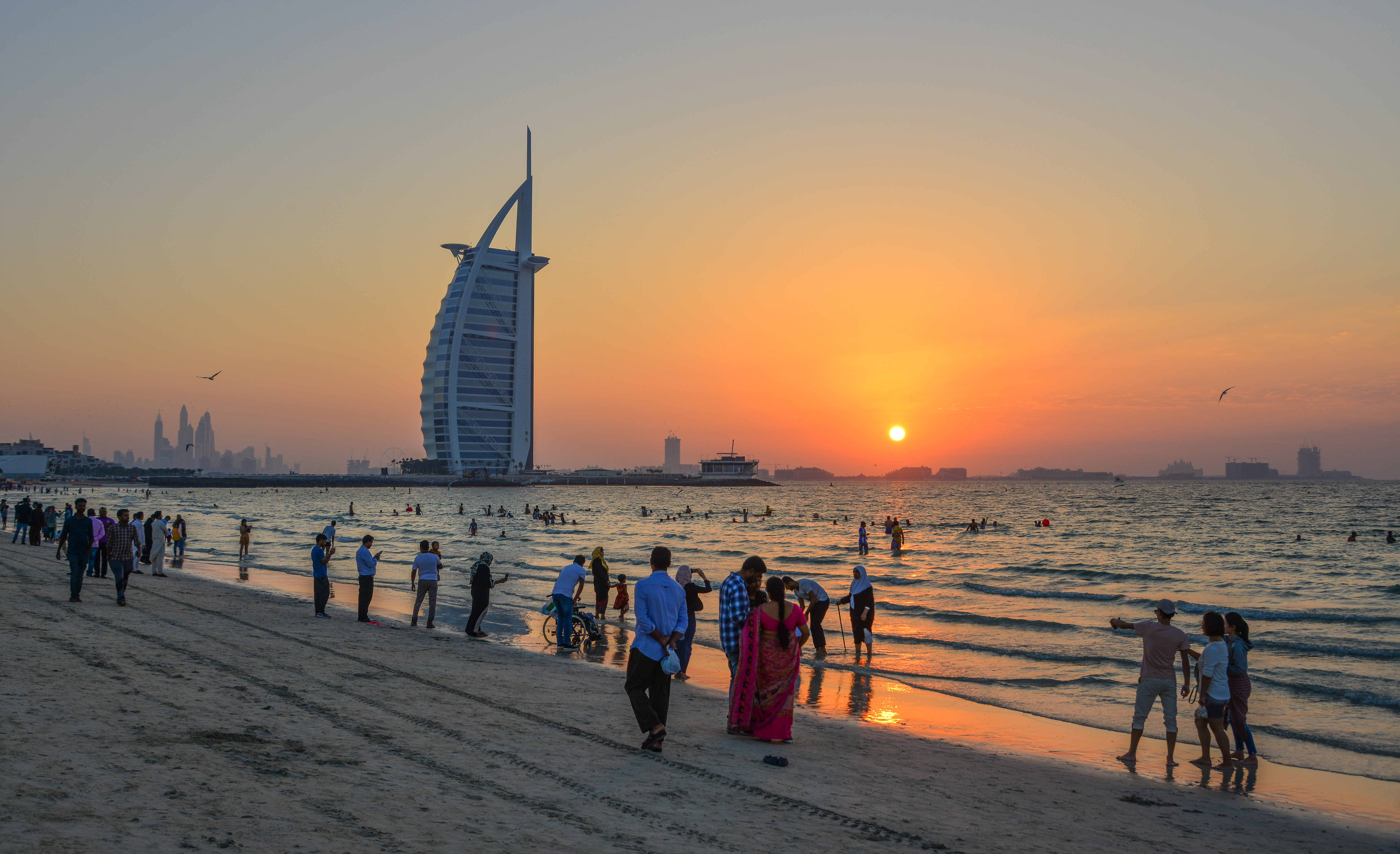 Pristine beach near Burj Al Arab in Dubai with golden sand, clear blue water, and the iconic hotel visible in the background