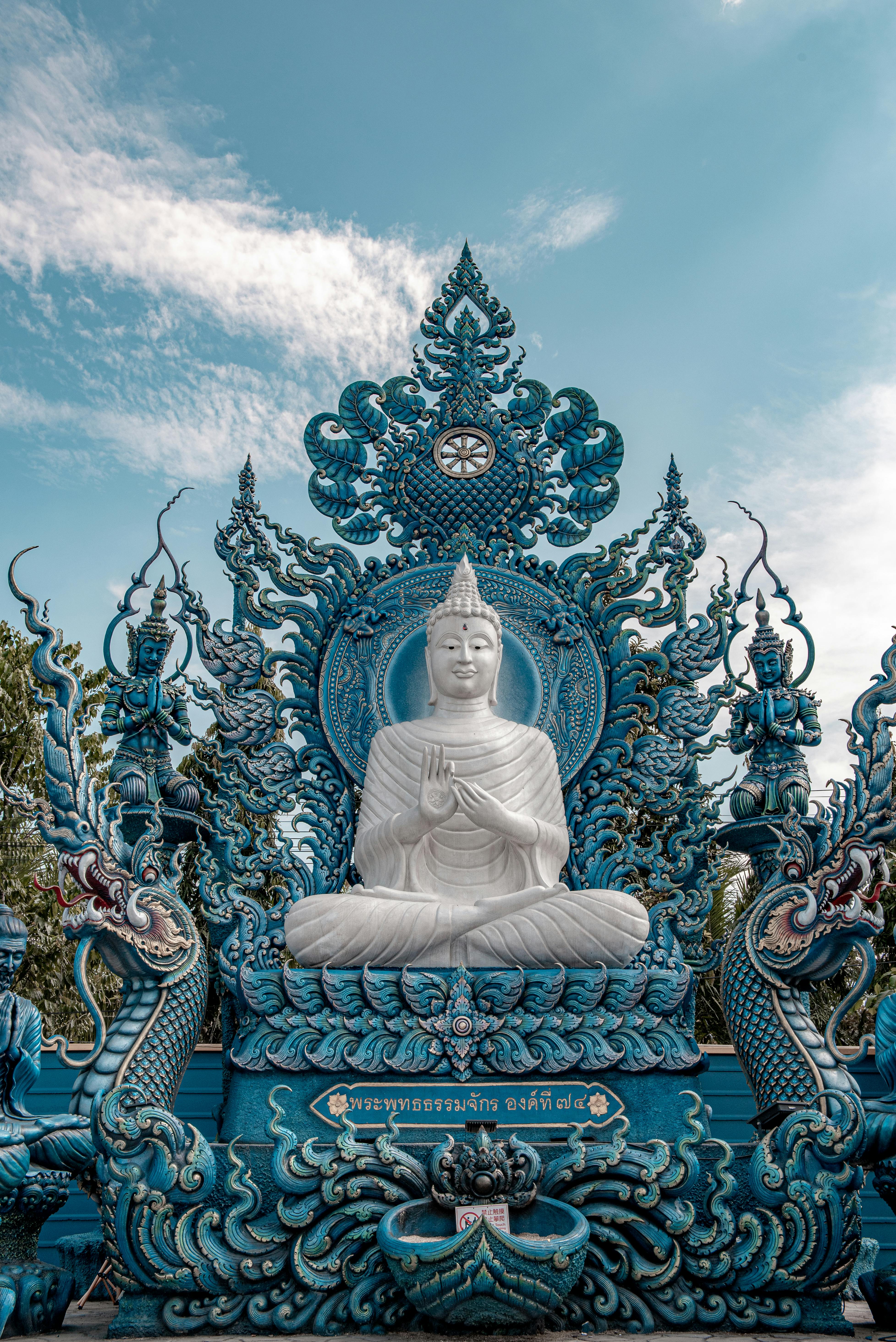 A stunning temple in Chiang Mai with golden spires and intricate carvings, set against a clear blue sky