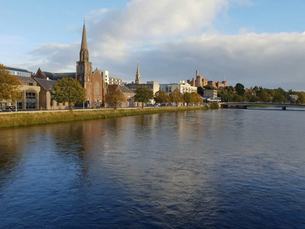 Inverness city in Scotland with buildings and greenery along the riverside of the River Ness