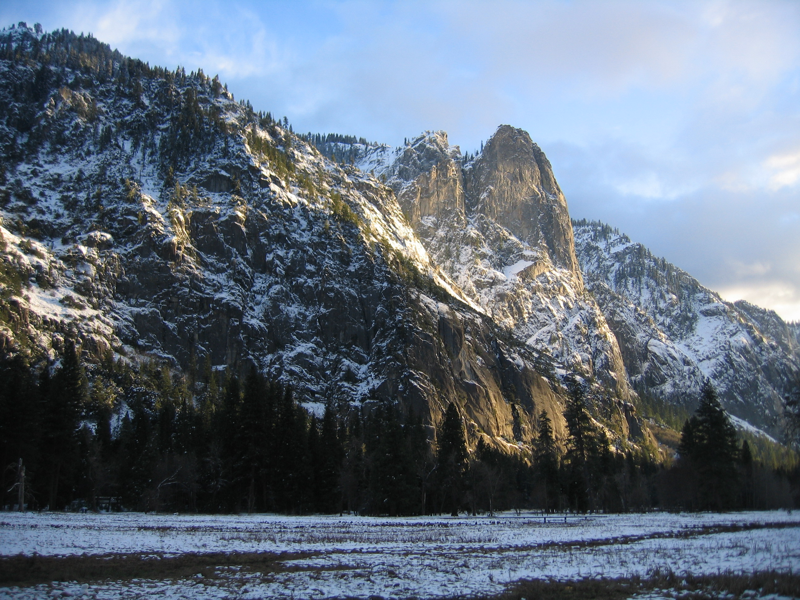 Cathedral Rocks in Yosemite Valley with towering granite formations and lush green trees at the base