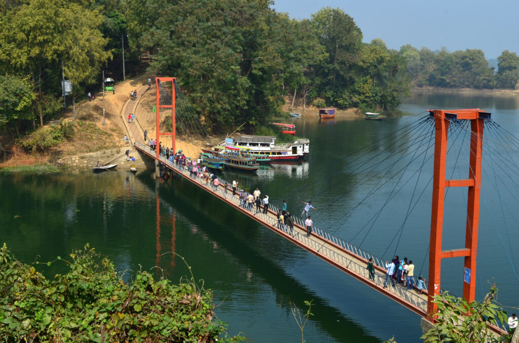 The iconic Hanging Bridge stretching over Kaptai Lake, surrounded by the lush green hills of Rangamati, Bangladesh.
