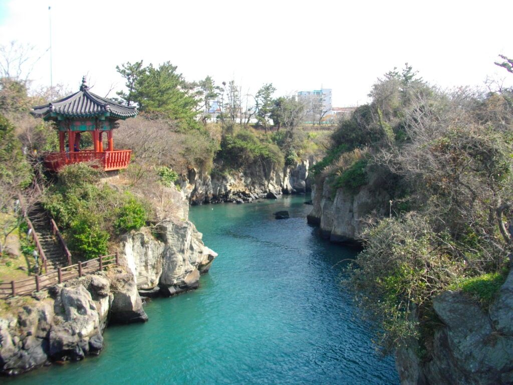 A breathtaking landscape of Hallasan Mountain covered in lush greenery, with a clear blue sky above in Jeju-si, South Korea