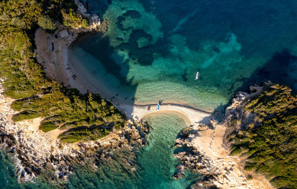 A panoramic view of Ksamil beach with clear blue waters and small islands in the distance