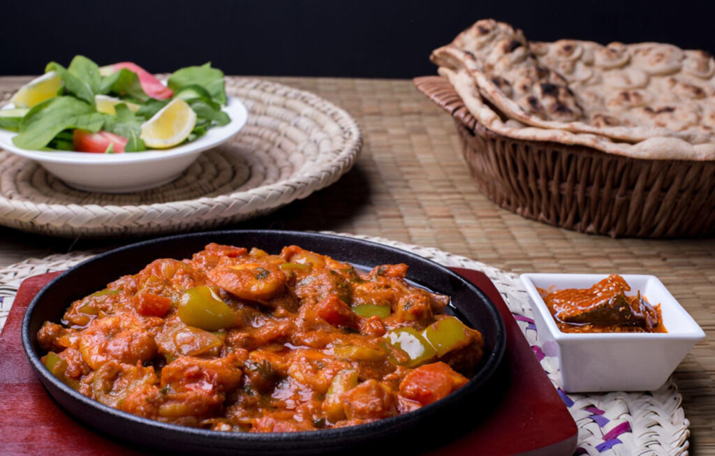 Close-up of a traditional Kuwaiti Machboos dish with spiced rice and grilled meat.