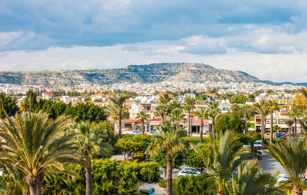 A picturesque view of Larnaca City with the coastline in the foreground and mountains visible in the background