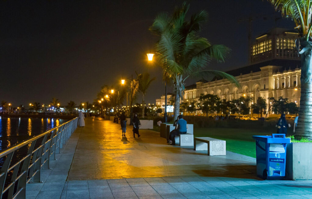 Jeddah nightlife scene with illuminated buildings and lively streets.