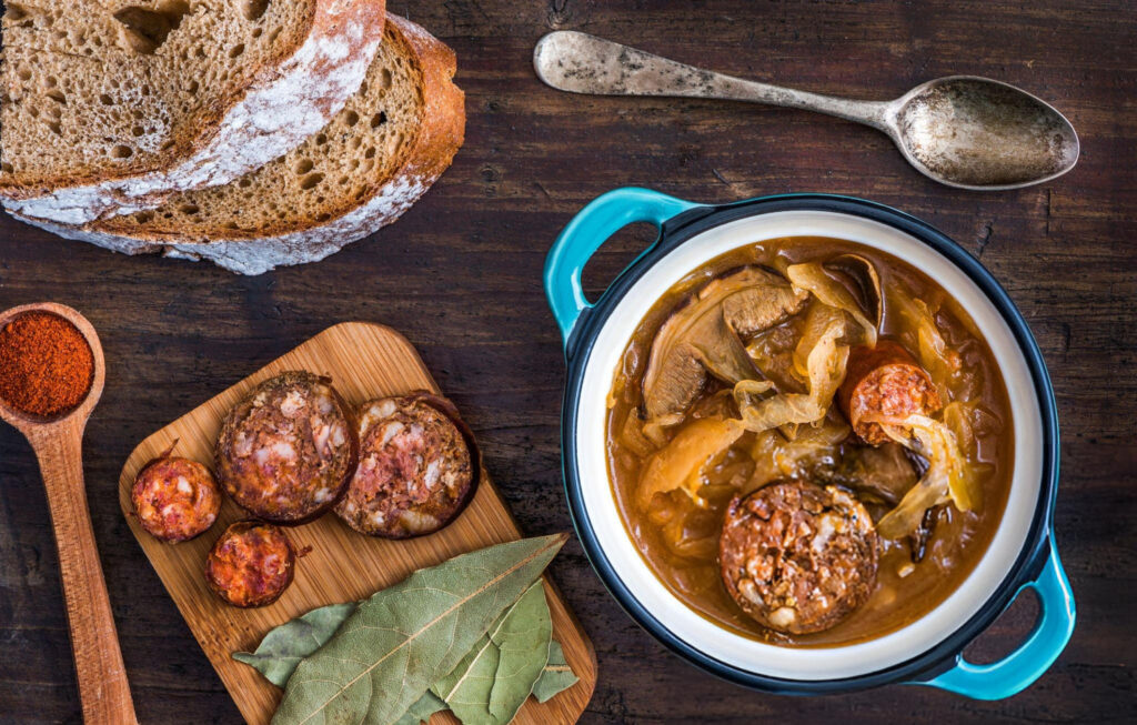 A traditional Czech meal featuring roasted pork, dumplings, and sauerkraut, served on a wooden table in Český Krumlov.