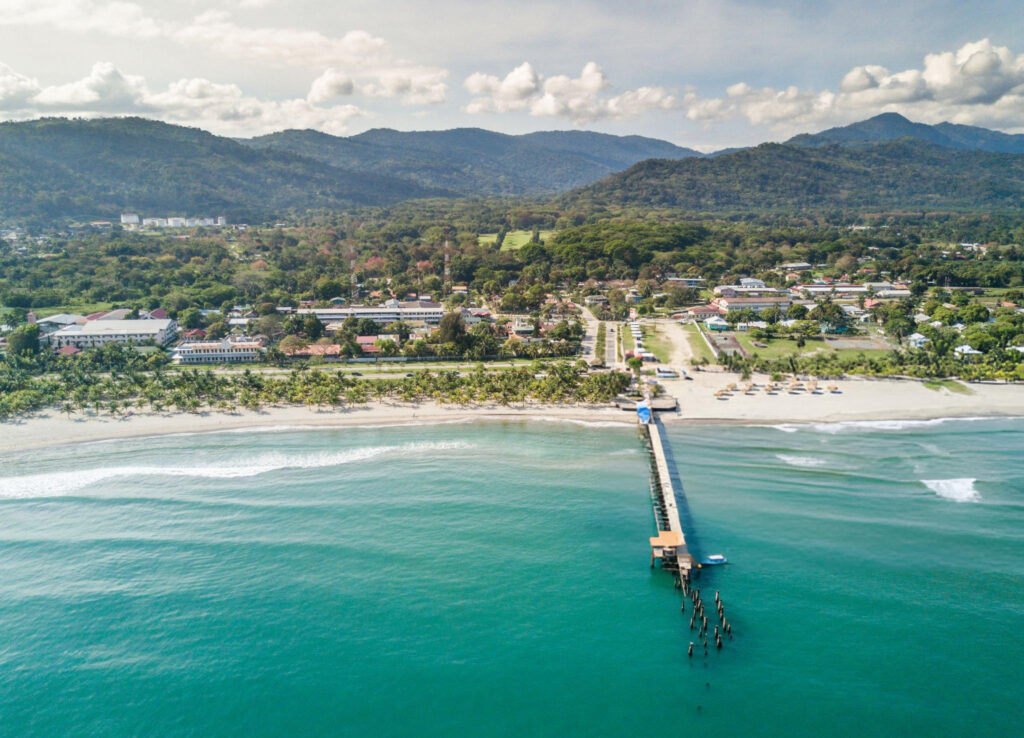 Aerial view of Tela, a coastal town in Honduras with its beautiful beaches, lush greenery, and the Caribbean Sea.