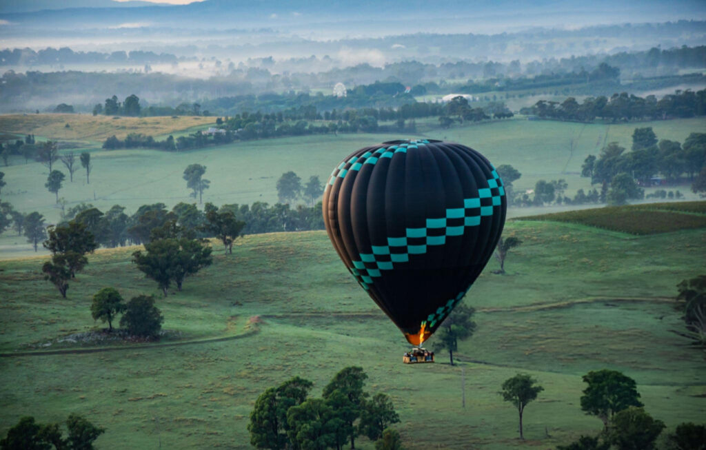 hot air balloons in hunter valley Colorful hot air balloons soaring over the picturesque vineyards of Hunter Valley during sunrise, with rolling hills and lush landscapes below