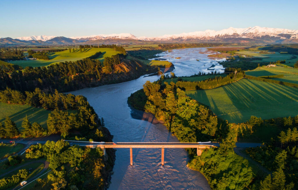 Waimakariri River flowing through the scenic landscape of Canterbury, New Zealand, with clear blue waters and mountain views in the background