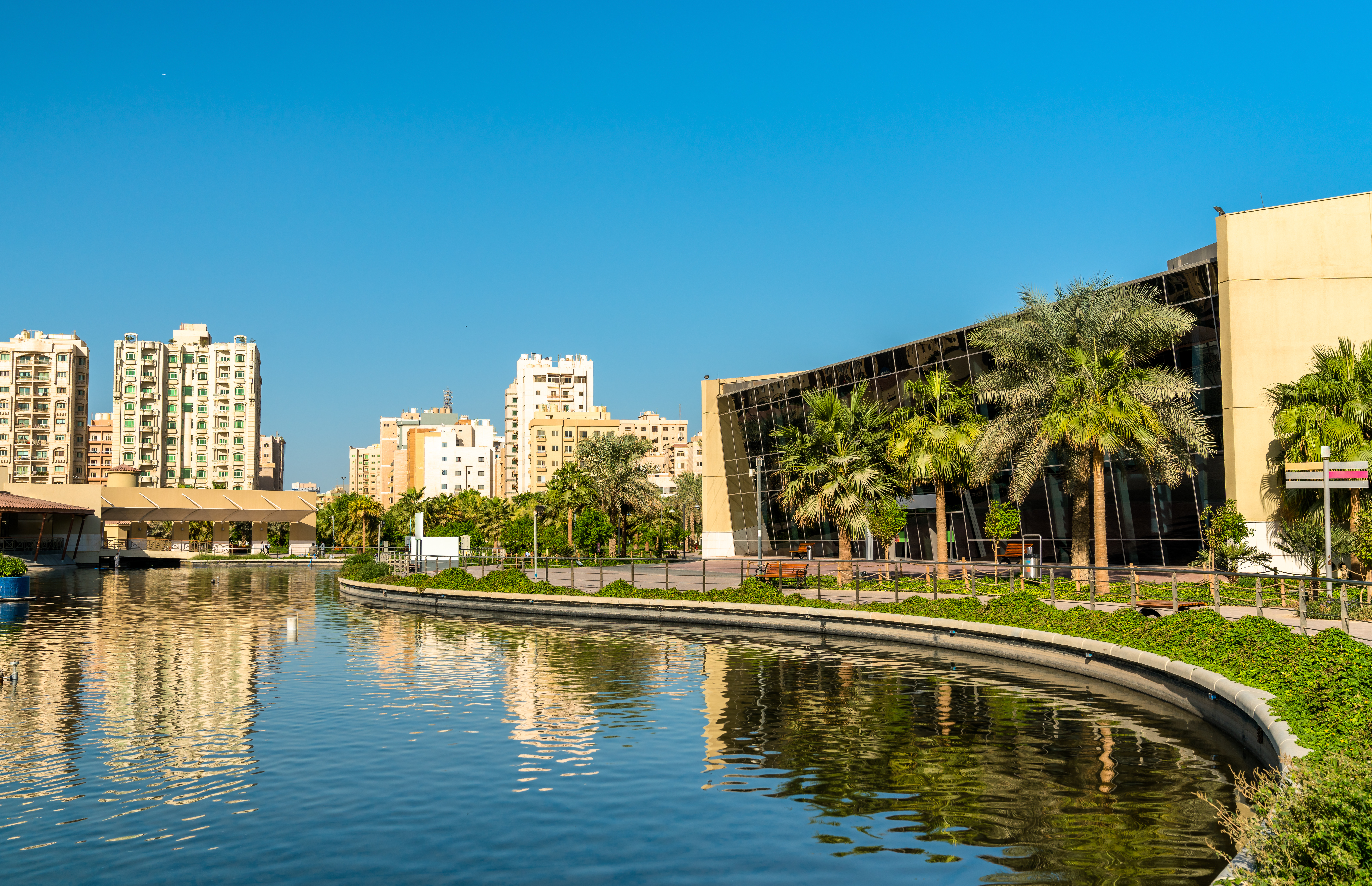 Scenic view of Al Shaheed Park in Kuwait City with lush greenery and visitors.