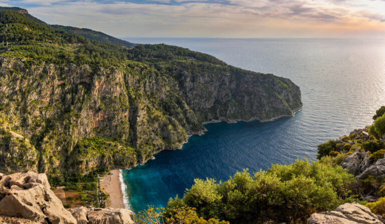 A serene beach at Butterfly Valley with turquoise waters and steep cliffs