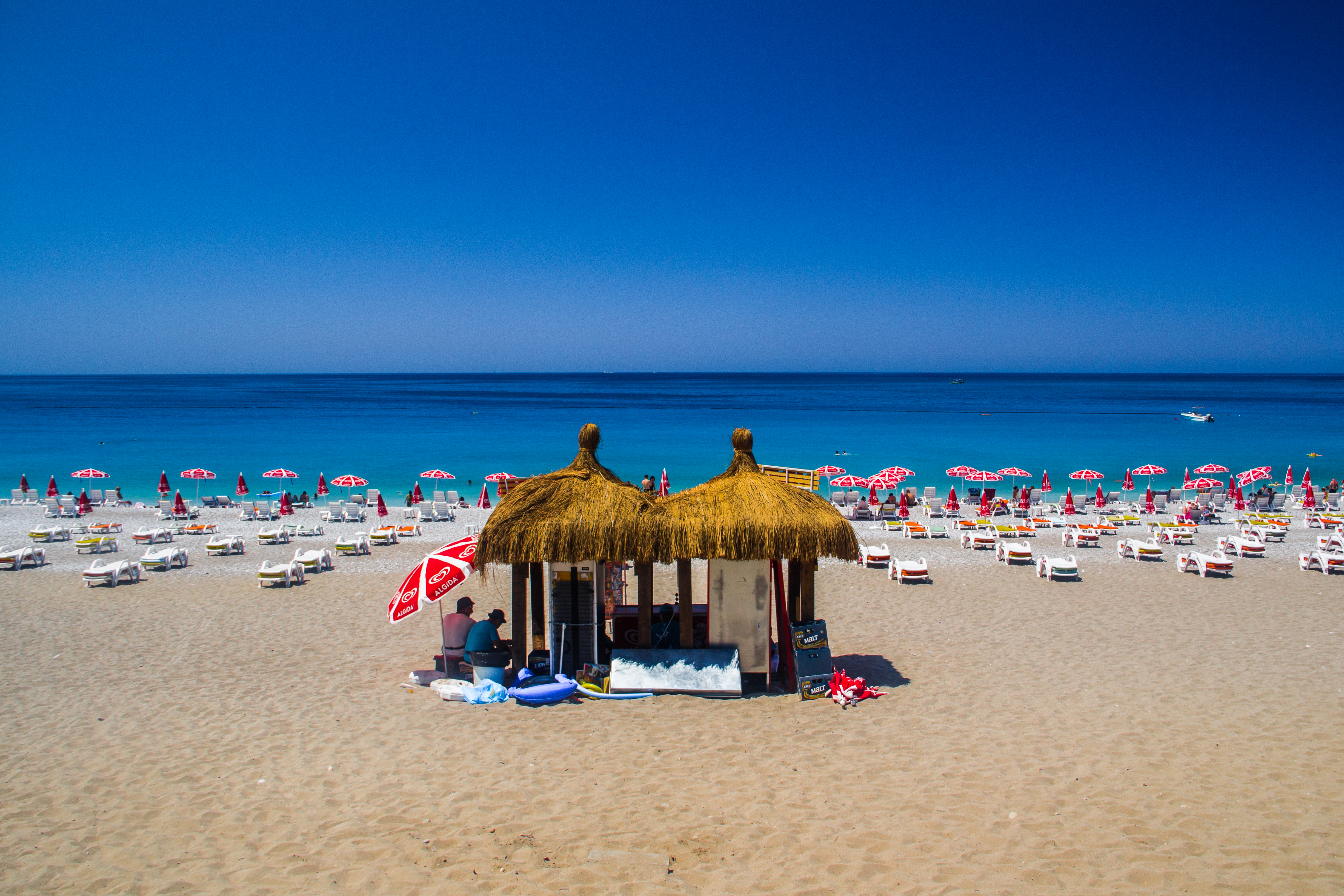 Panoramic view of Ölüdeniz Beach in Turkey, showcasing the Blue Lagoon, turquoise waters, sandy beach, and surrounding lush mountains