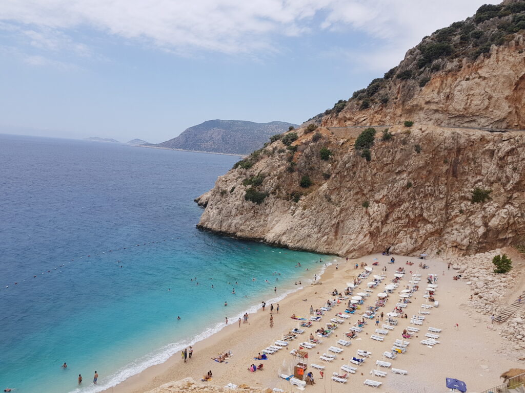 Kaputaş Beach in Antalya, Turkey, with turquoise water, sandy shore, and dramatic cliffs in the background