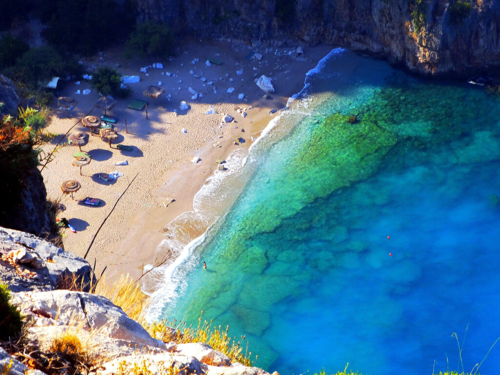 A breathtaking view of Butterfly Valley, Turkey, with steep cliffs, lush greenery, and the turquoise Mediterranean Sea