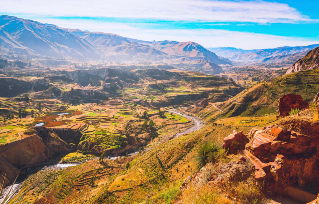 A panoramic view of Colca Valley, Peru, with deep canyons, lush valleys, and mountain ranges