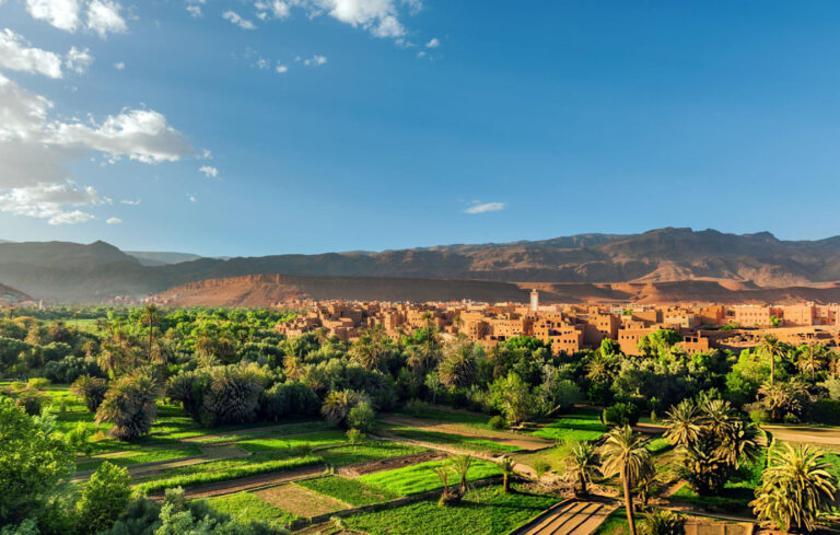 A panoramic view of Dades Valley in Morocco, showcasing its rugged cliffs, lush green oases, and winding river