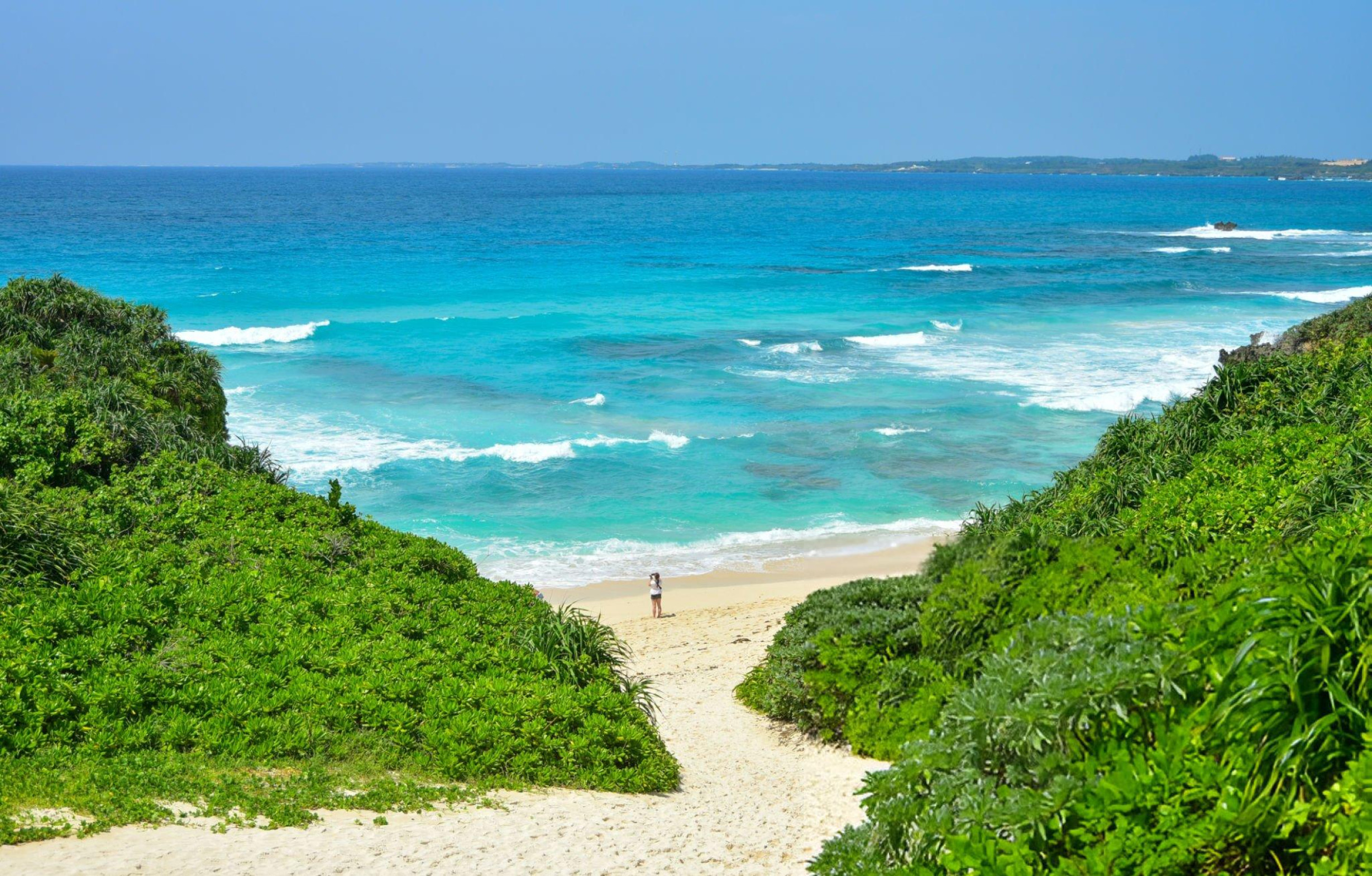 Sunayama Beach on Miyako Island, Okinawa, Japan, with soft white sand, clear turquoise waters, and lush green vegetation framing the shore