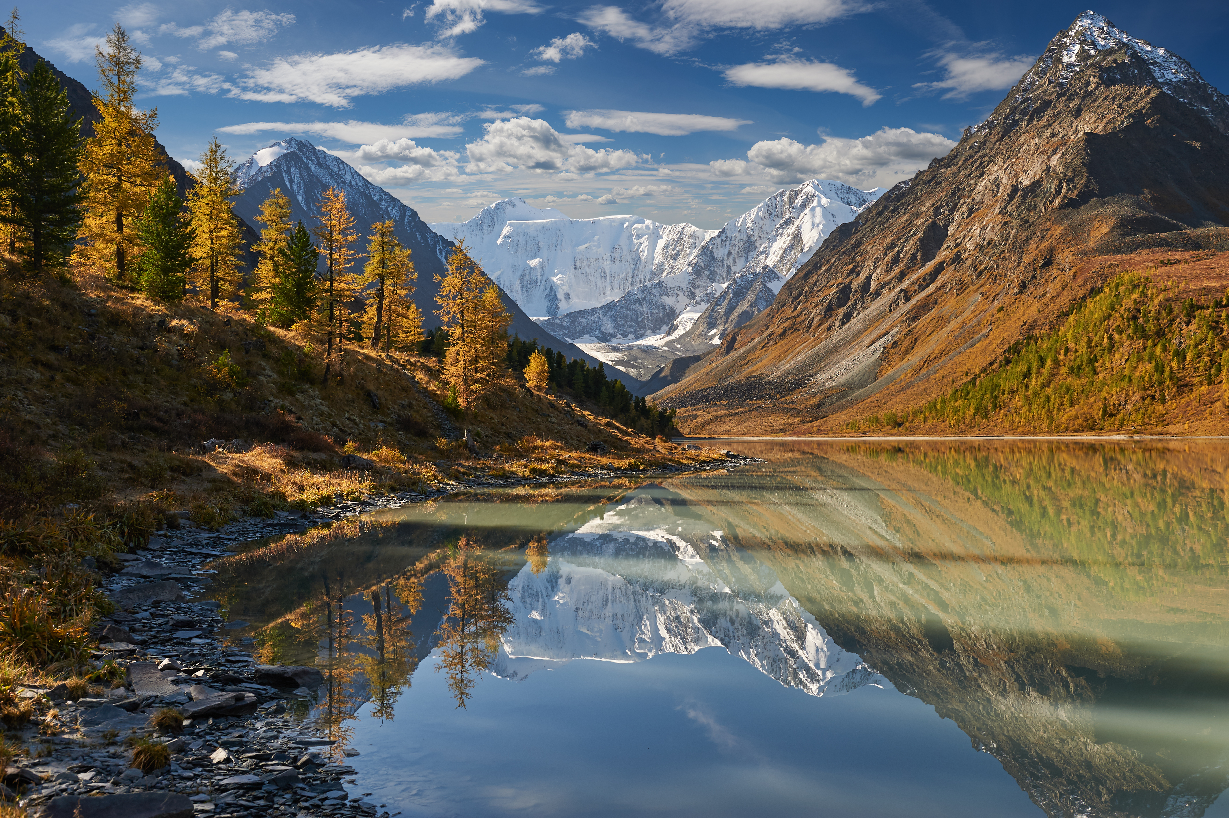 Winding river flowing through the Altai Valley with a backdrop of rugged mountains and green valleys