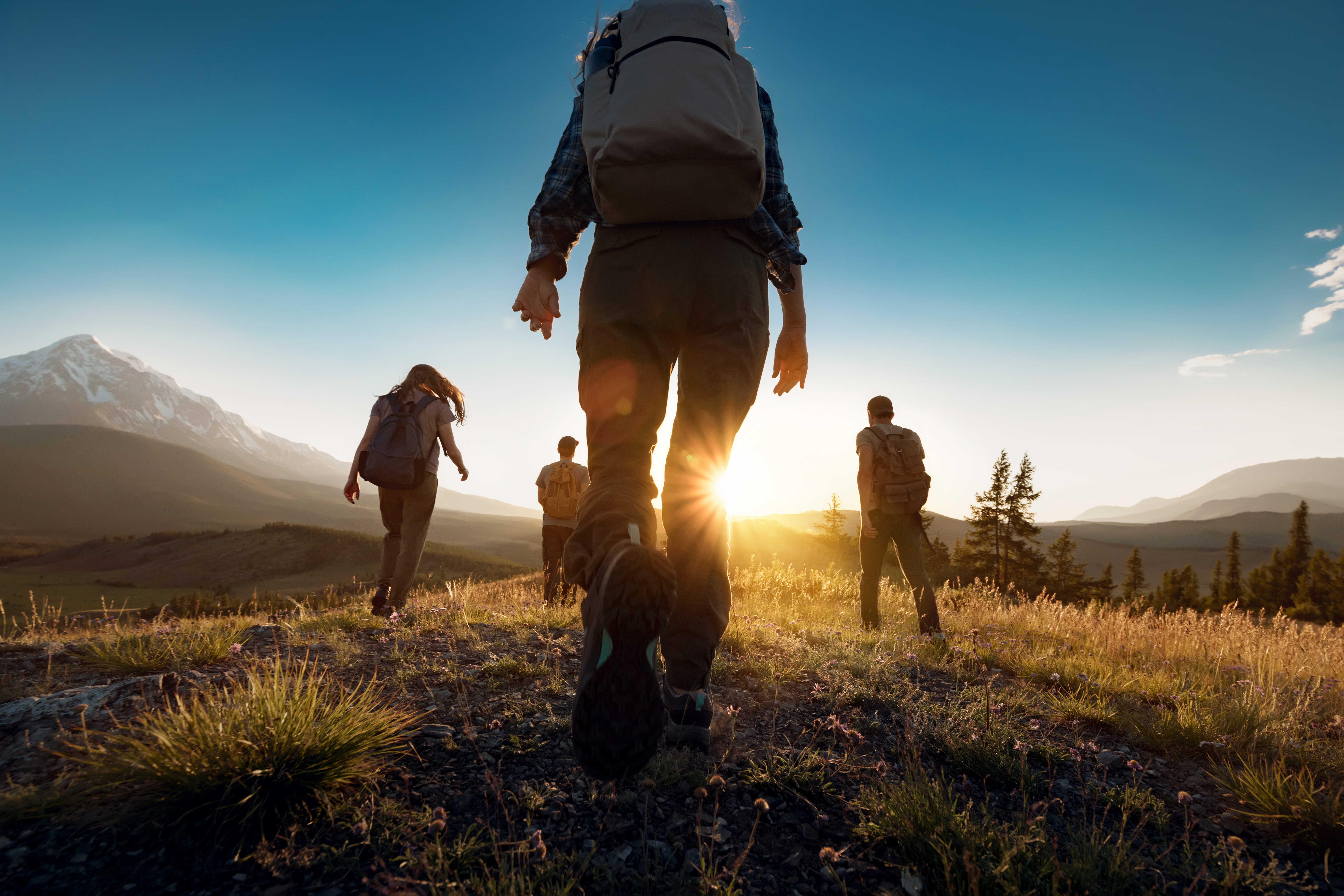 Hikers walking along a rocky trail in Chapada dos Veadeiros Valley, Brazil, with scenic views of rugged cliffs and green landscapes